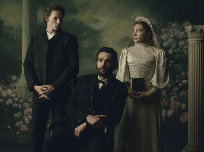 Florence Pugh as a bride alongside two men in a period drama scene.