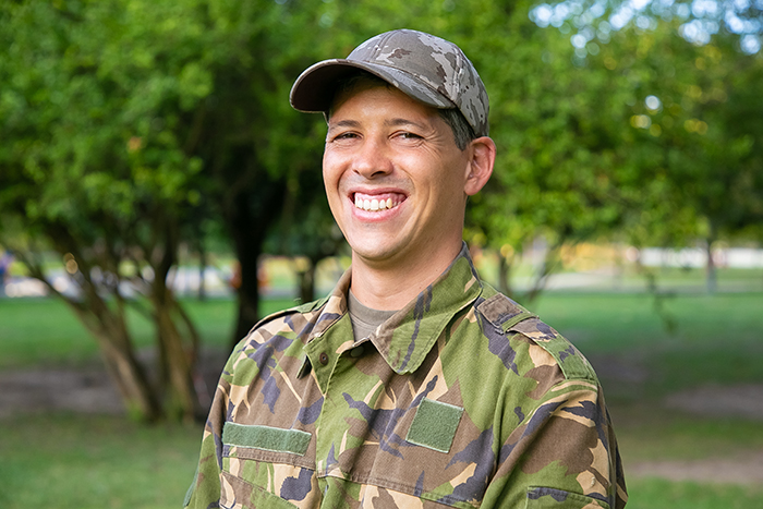 A smiling military man in camouflage gear after making his own way when parents dismiss son’s achievements. A smiling military man in camouflage gear after making his own way when parents dismiss son’s achievements.