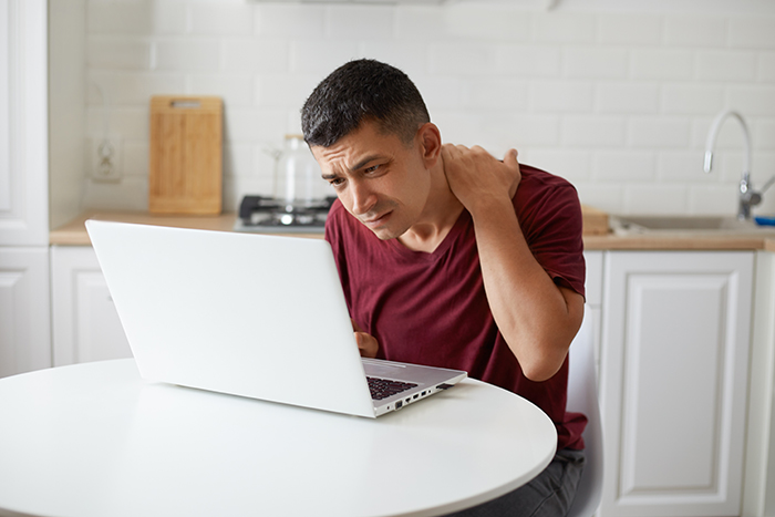 A man looking stressed at his laptop as parents dismiss son's achievements and demand a relationship. A man looking stressed at his laptop as parents dismiss son's achievements and demand a relationship.