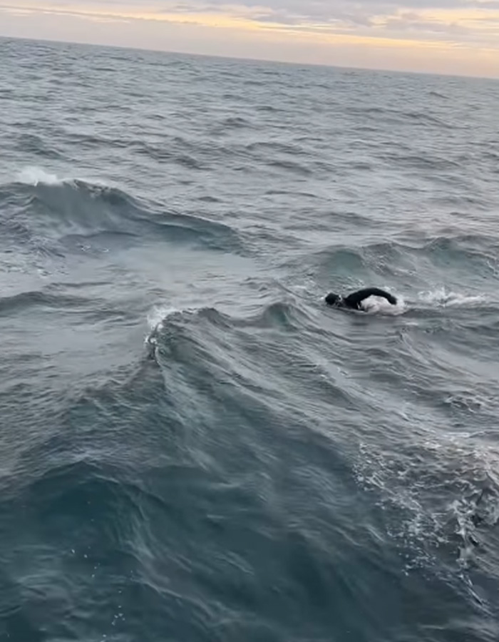 Extreme swimmer navigating through rough ocean waves during a long-distance challenge. Extreme swimmer navigating through rough ocean waves during a long-distance challenge.