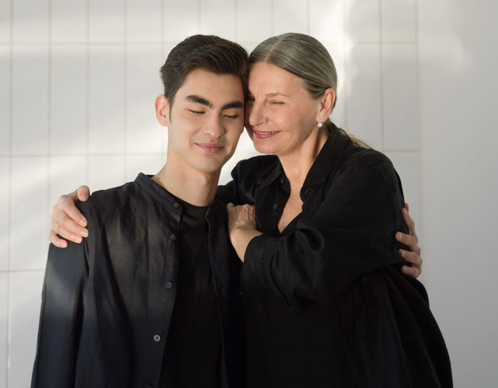 Mom hugging her smiling adult son in a warm family moment Mom hugging her smiling adult son in a warm family moment