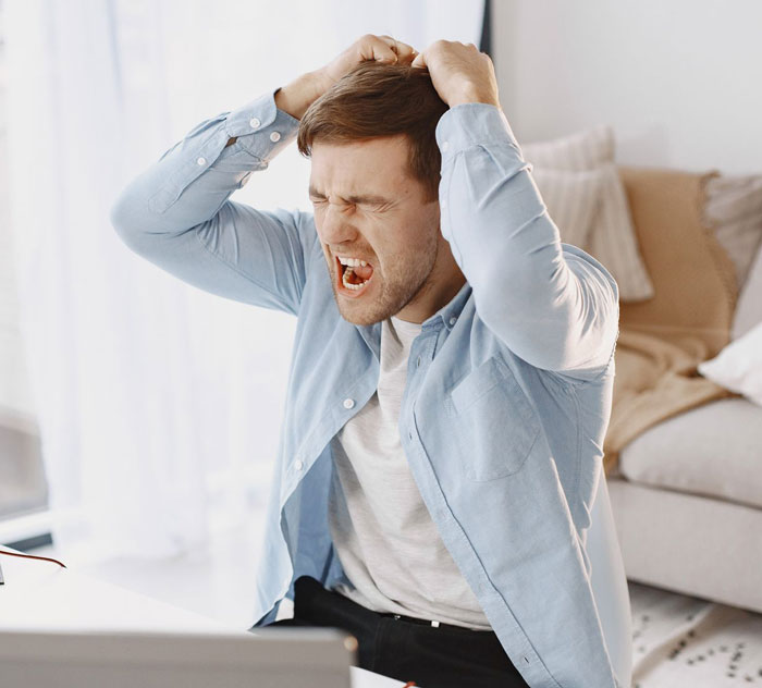 A frustrated man clutching his hair, showing anger and regret after his ex-fianc&eacute; took petty revenge.
