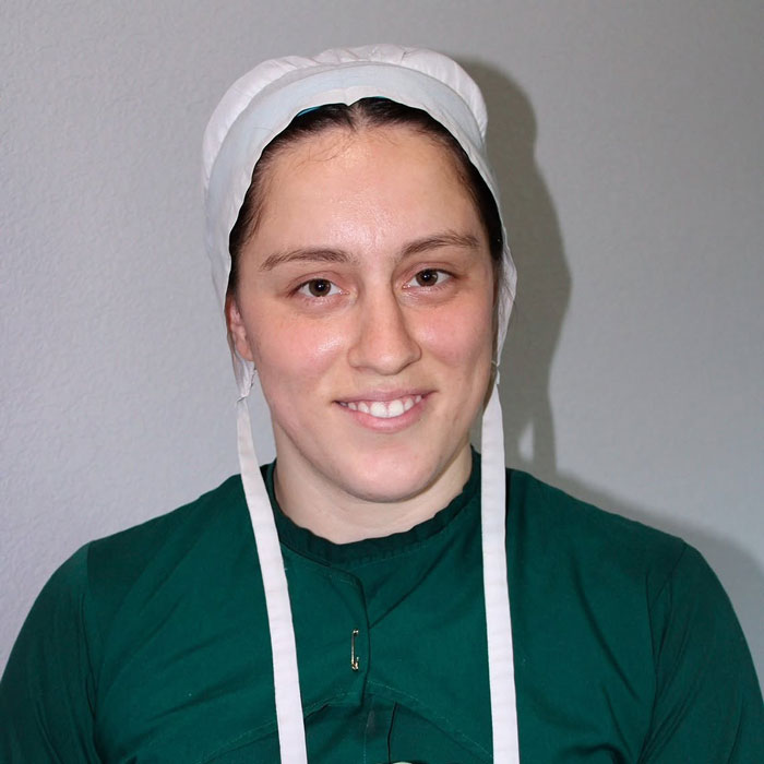 Portrait of Lovina Zook wearing traditional Amish head covering and green dress Portrait of Lovina Zook wearing traditional Amish head covering and green dress