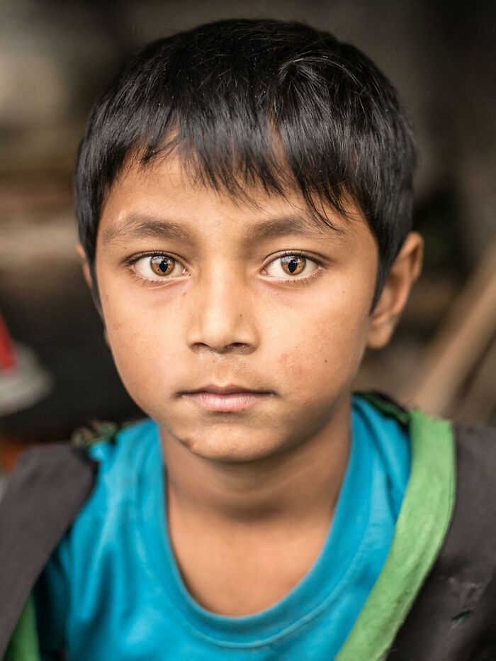 An interesting pic of a boy with unique golden-colored eyes starring directly into the camera