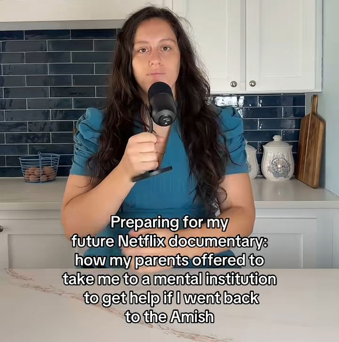 Lovina Zook holding a microphone and talking about growing up Amish Lovina Zook holding a microphone and talking about growing up Amish
