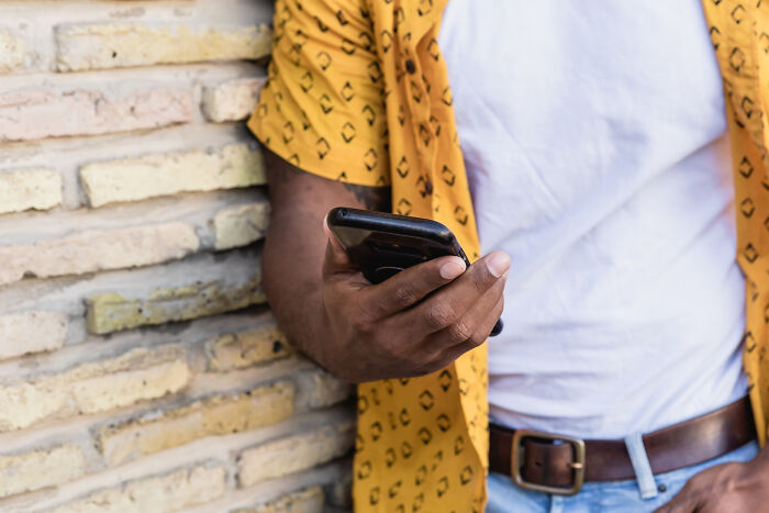 Close-up of a person holding a phone, highlighting the impact of a Facebook comment on free speech. Close-up of a person holding a phone, highlighting the impact of a Facebook comment on free speech.