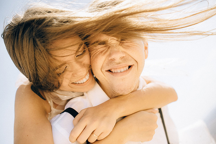 Happy young couple hugging outdoors before a dream proposal after 3 years together