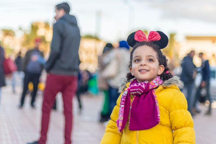A happy young girl wearing Minnie Mouse ears on a family trip to Disneyland. A happy young girl wearing Minnie Mouse ears on a family trip to Disneyland.