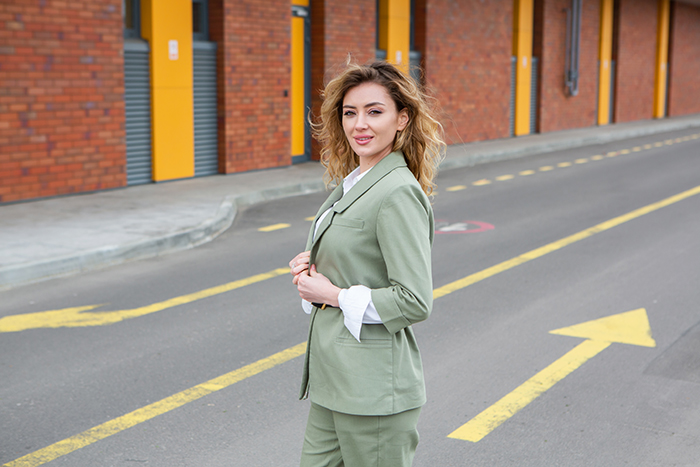 Woman posing outdoors wearing a stylish light green suit, showing how she dresses. Woman posing outdoors wearing a stylish light green suit, showing how she dresses.
