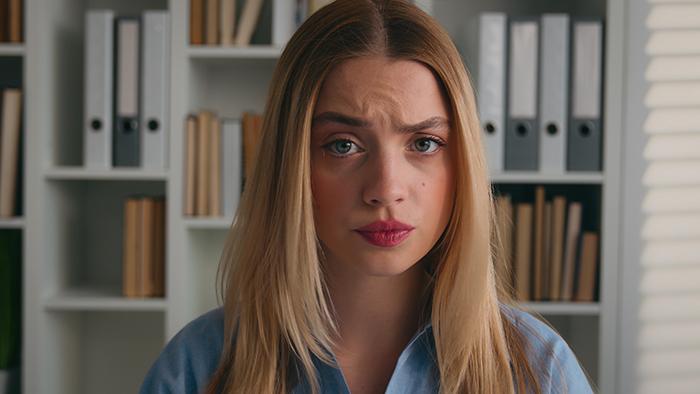 A worried woman in a library setting, representing a brother asked to control his wife. A worried woman in a library setting, representing a brother asked to control his wife.