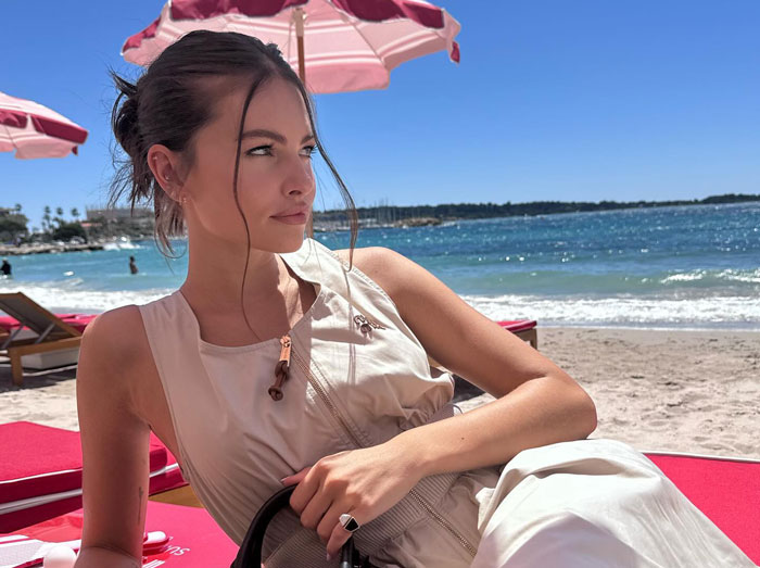 French model Thylane Blondeau relaxing on a beach lounge chair under a pink umbrella French model Thylane Blondeau relaxing on a beach lounge chair under a pink umbrella
