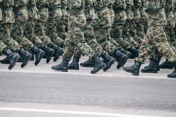Soldiers marching in camouflage uniforms, representing military PR stunts in public events.
