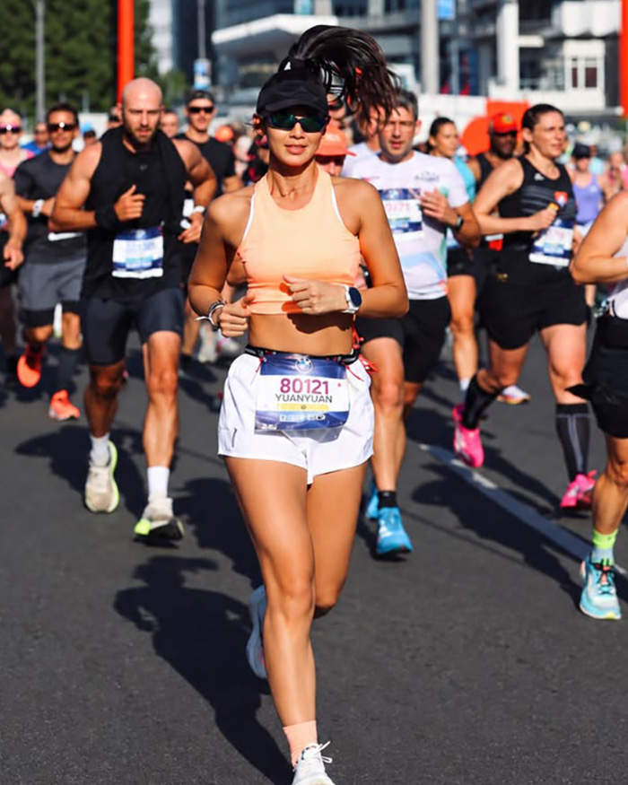 Fitness influencer running alongside other competitors during a marathon event Fitness influencer running alongside other competitors during a marathon event