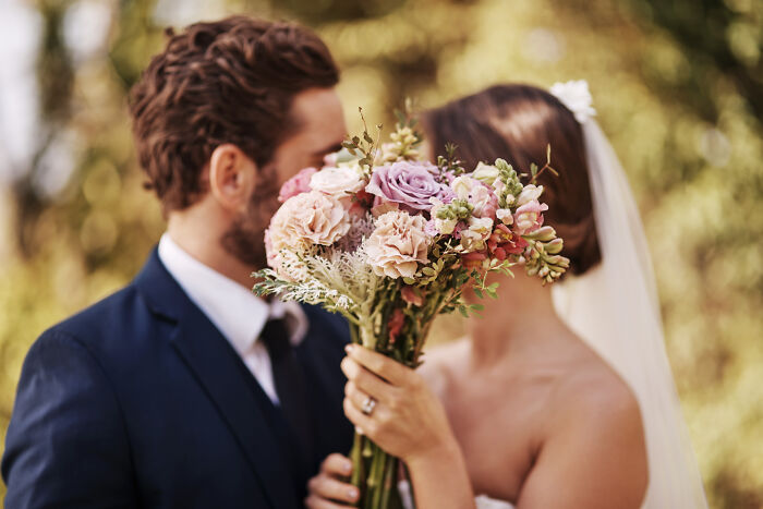 Bride and groom holding a bouquet, representing people disowned by their families due to marriage choices.