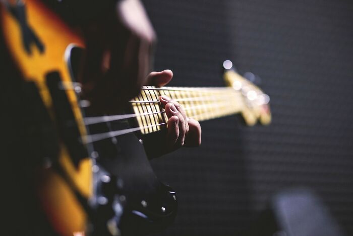 Close-up of a musician playing bass guitar, symbolizing hobbies men pursue when they walk away from marriage