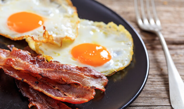 A plate of fried eggs and bacon, inspired by iconic PR stunts in food history.