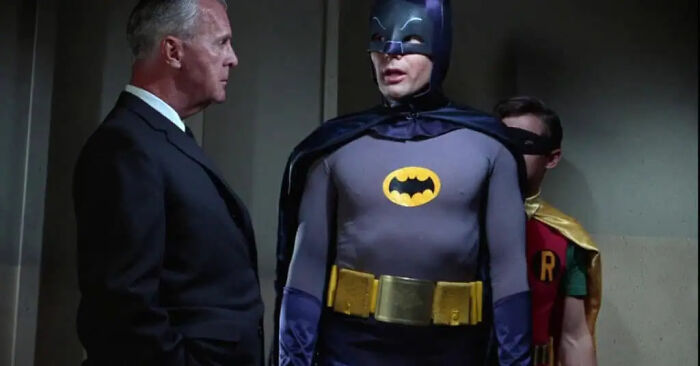 Adam West as Batman wearing a classic utility belt as a memorable movie prop.