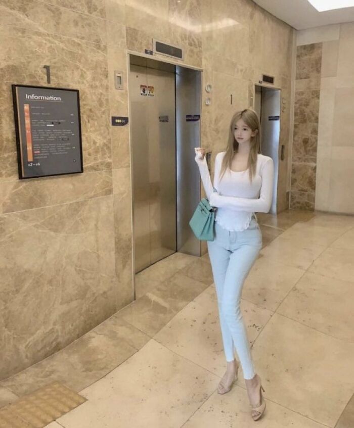 Photo with extremely edited tall and slim figure in a building lobby