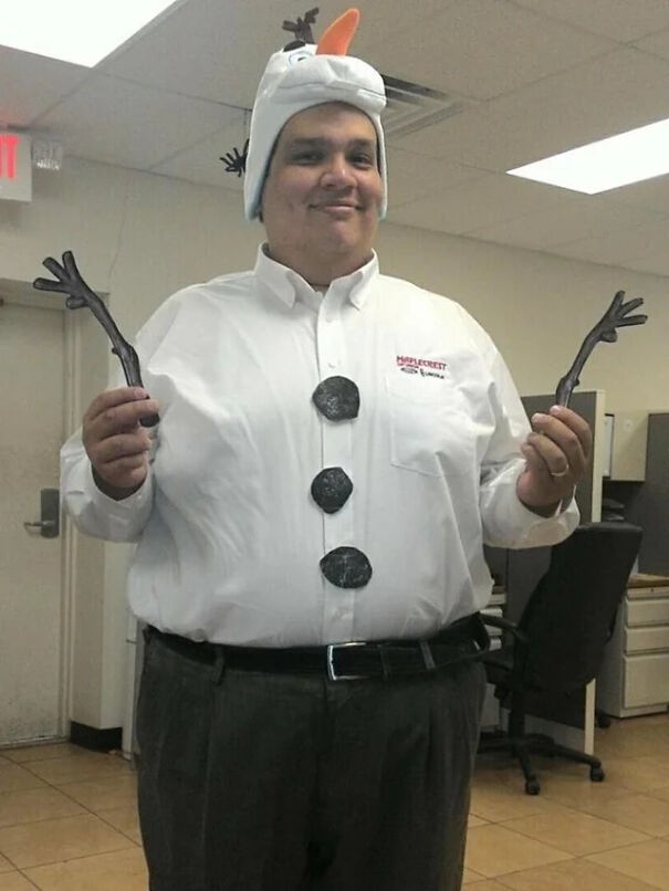 A man wearing a snowman hat and white shirt with paper coal buttons showcasing a fun Halloween costume idea.