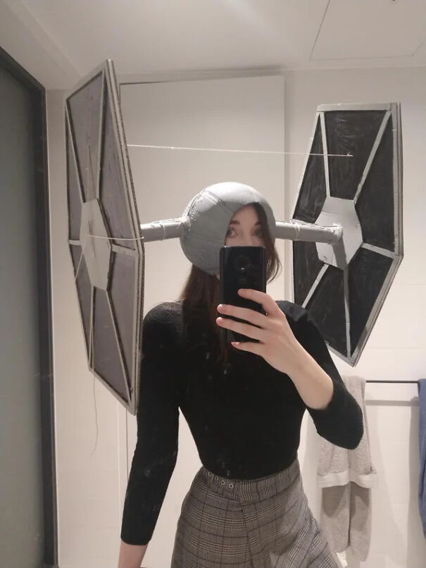 A woman wearing a DIY TIE Fighter headpiece as a creative Halloween costume idea.