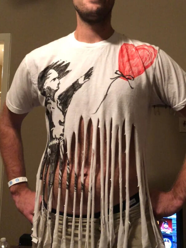 A man wearing a Banksy shredded Girl with Balloon t-shirt Halloween costume.