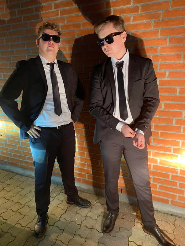 Two men in suits and sunglasses posing together as a stylish Halloween costume idea.