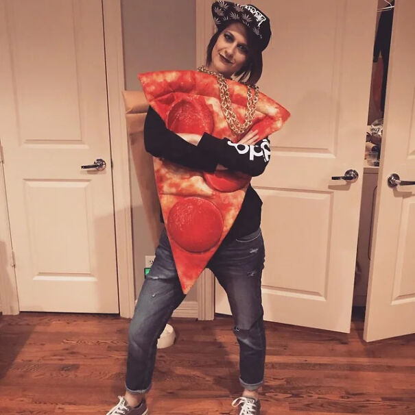 A woman wearing a fun, last-minute pizza slice Halloween costume complete with a snapback hat and chain necklace.