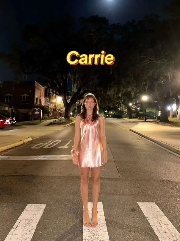 A woman posing in a blood-stained dress and tiara as a Carrie Halloween costume idea.
