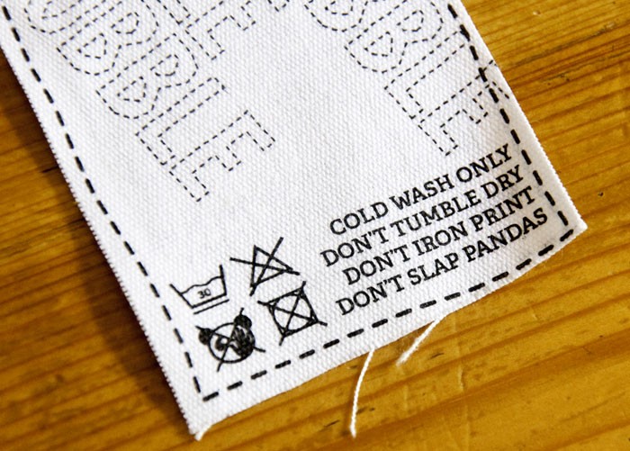 Fabric tag displaying funny and confusing labels and instructions including DON'T SLAP PANDAS.