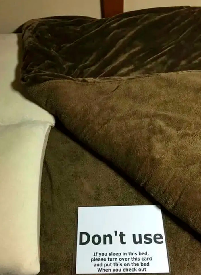 A sign on a hotel bed with confusing instructions about sleeping on it.