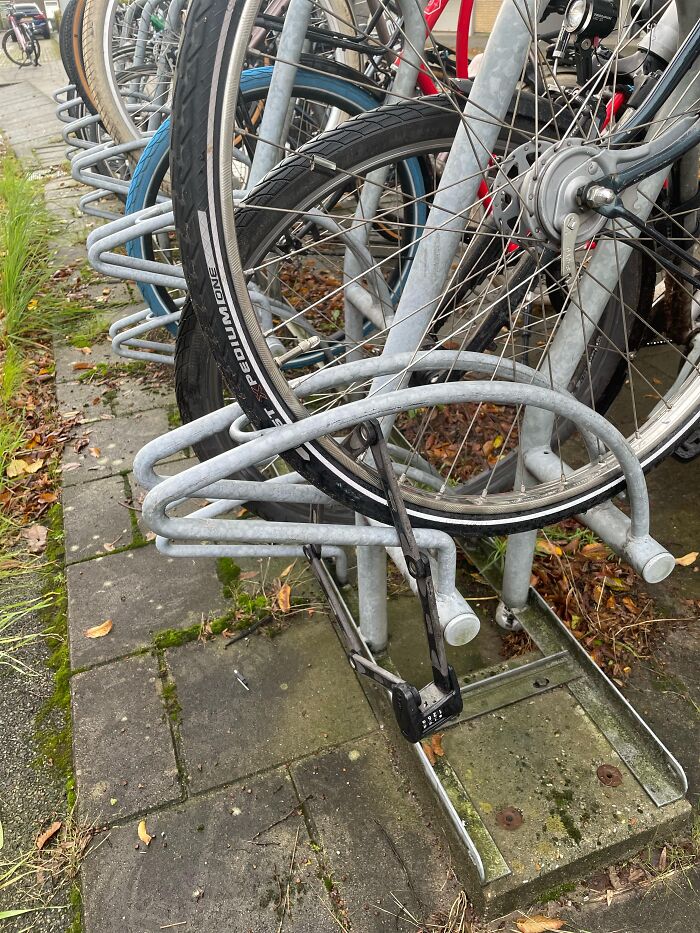 Absurd moment showing a bicycle lock secured only to a bike rack without the bike