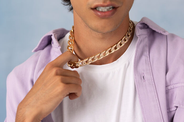 Man wearing gold chain necklace discovered among valuable dumpster finds.