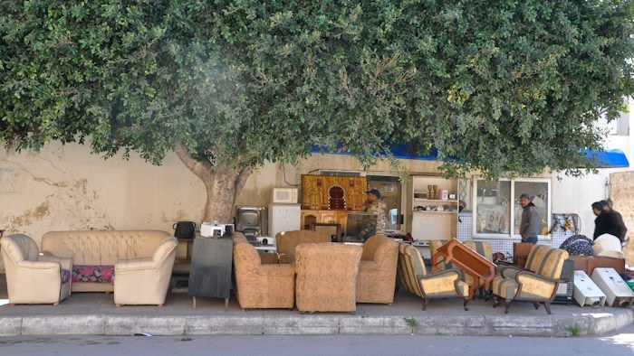 Assorted second hand furniture displayed outdoors showing dumpster finds