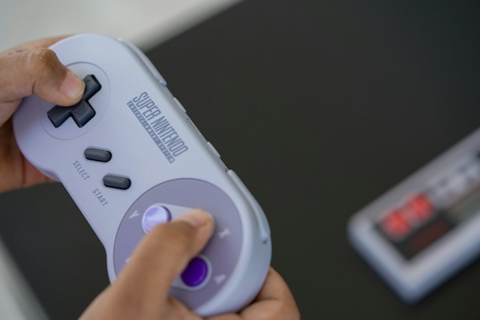 Person holding a retro video game controller as a dumpster finds treasure