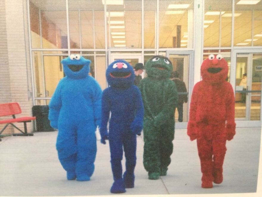 Four people dressed in Sesame Street mascot suits outside a building, showcasing fun creative Halloween costume ideas.