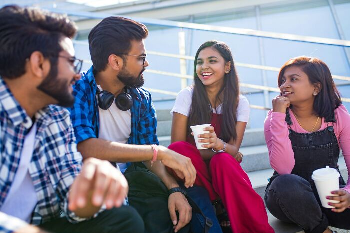 Two women and two men chat outside, highlighting how women refuse to tolerate toxic behaviors in social circles