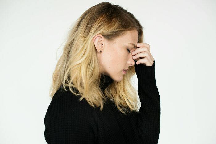 A blonde woman holding her forehead in frustration, demonstrating funny instances when folks failed.