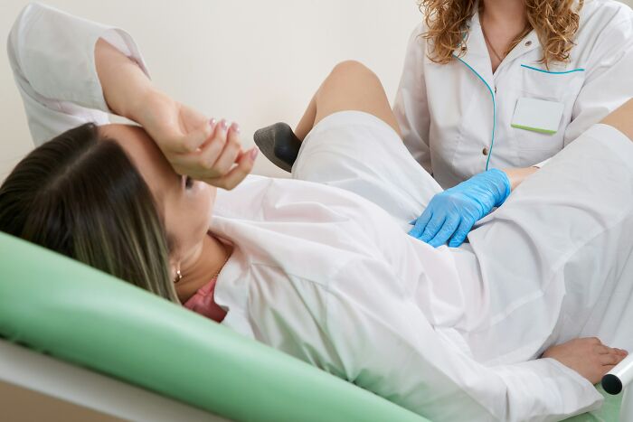 Female patient undergoing gynecological exam by medical professional