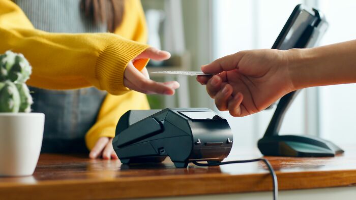 Customer paying with credit card using contactless payment at terminal