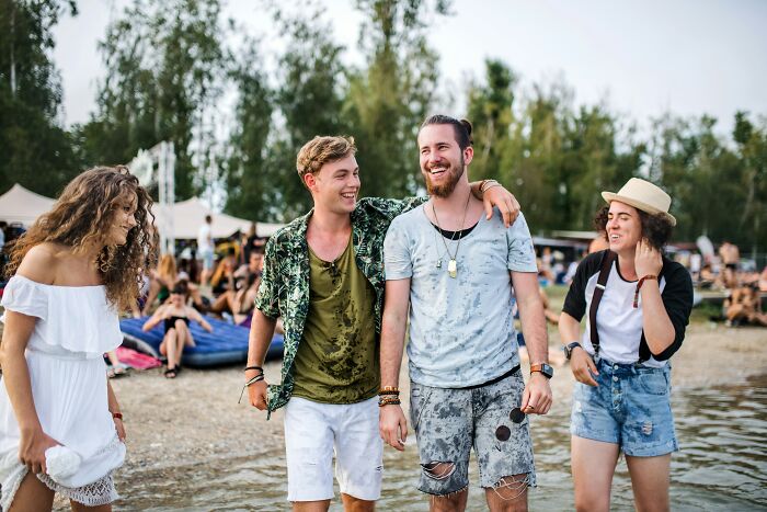 Group of friends enjoying summer beach, sharing survival stories and laughter