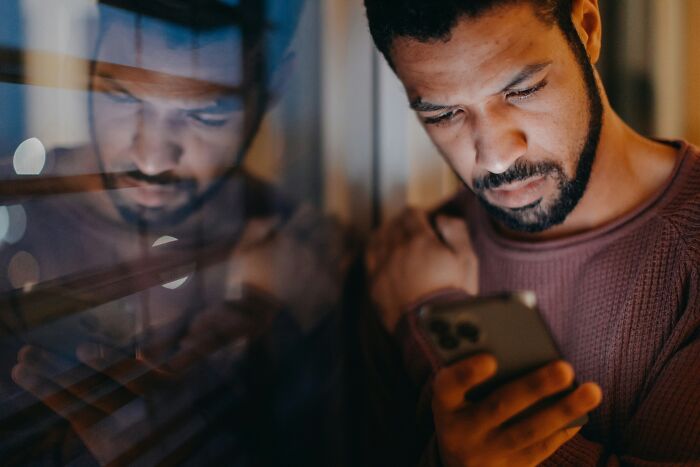 A man looking at a smartphone, reflecting modern PR stunts in digital media.