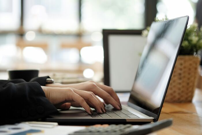 A person typing on a laptop, representing digital marketing strategies for PR stunts.