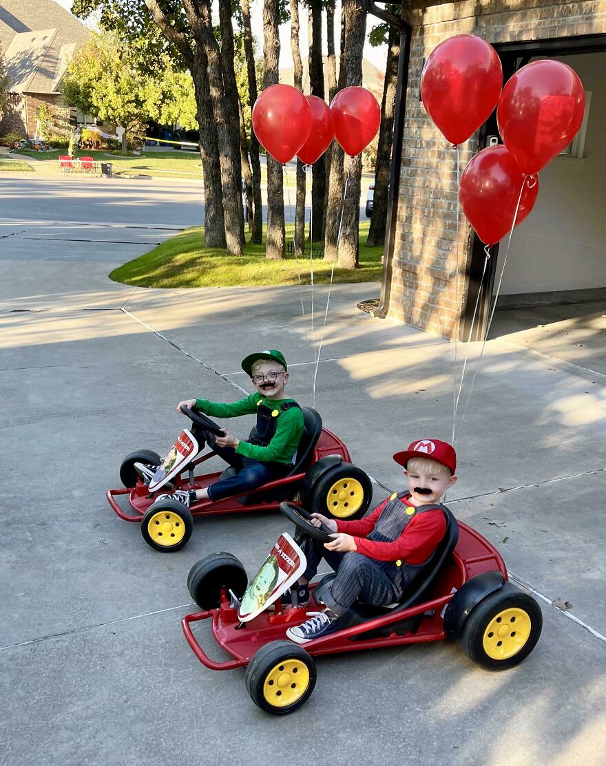 Two kids in Mario and Luigi go-karts with red balloons, showcasing creative Halloween costume ideas.