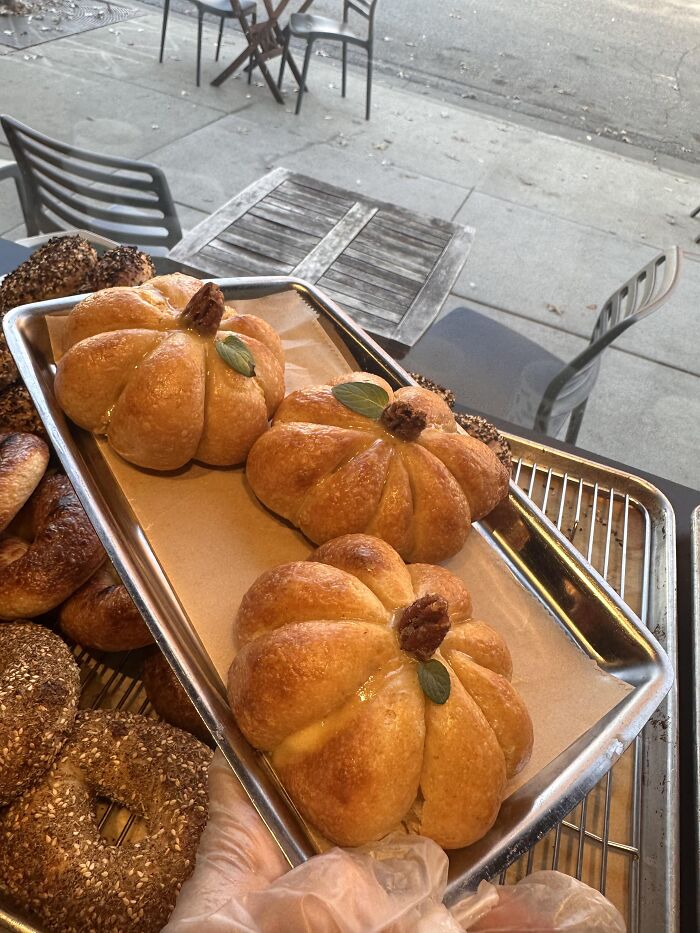 Tray of golden-baked pumpkin-shaped rolls, a creative option for Halloween foods.