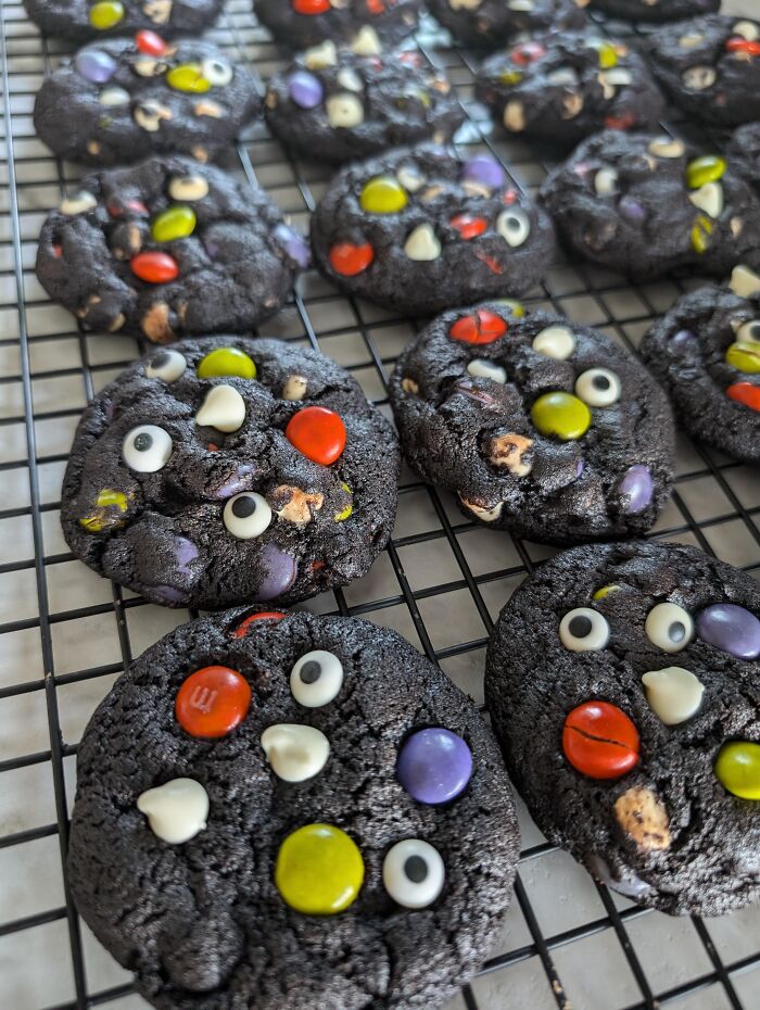 Dark chocolate Halloween foods styled as monster cookies decorated with candy eyes.