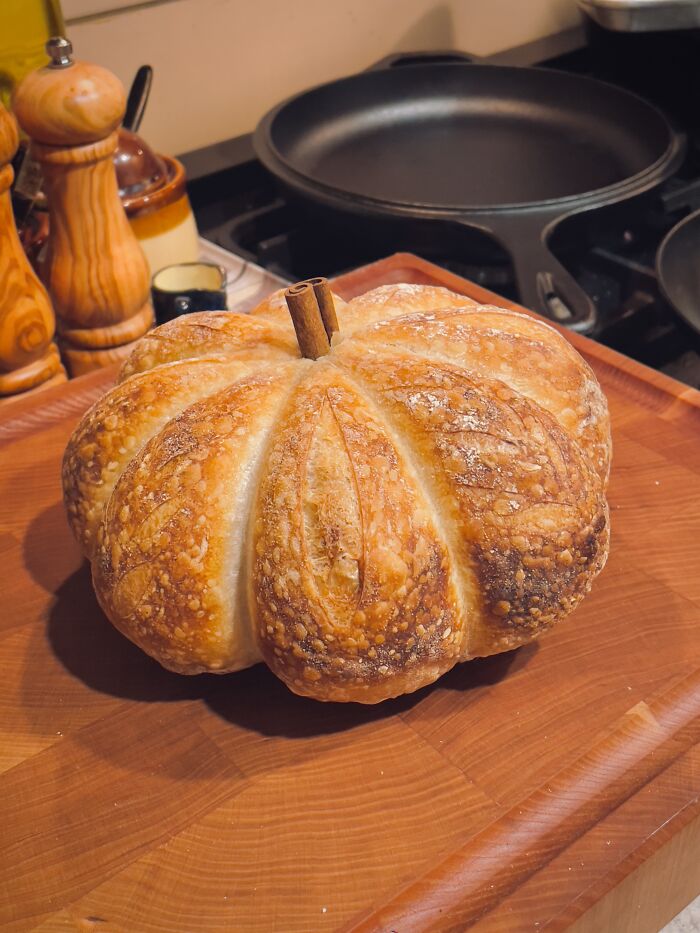 Freshly baked sourdough bread shaped like a pumpkin, a cozy idea for Halloween foods.