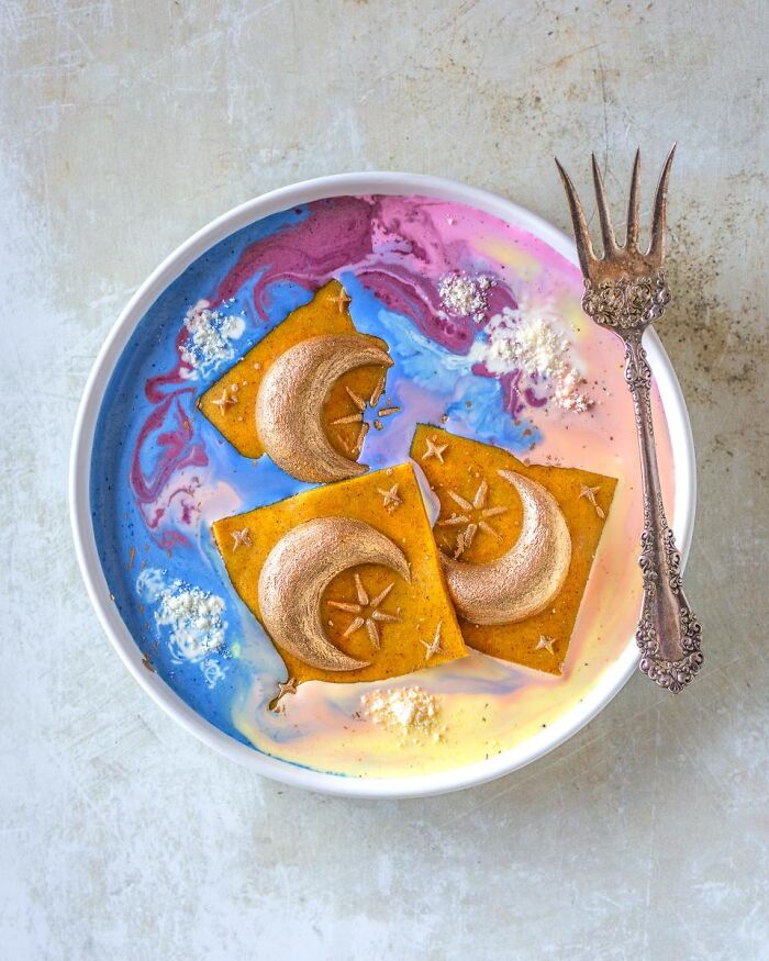Ethereal cosmic Halloween foods featuring moon-shaped pastries floating in a colorful swirl soup.