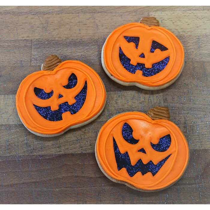 Pumpkin shaped frosted cookies as spooky Halloween foods.