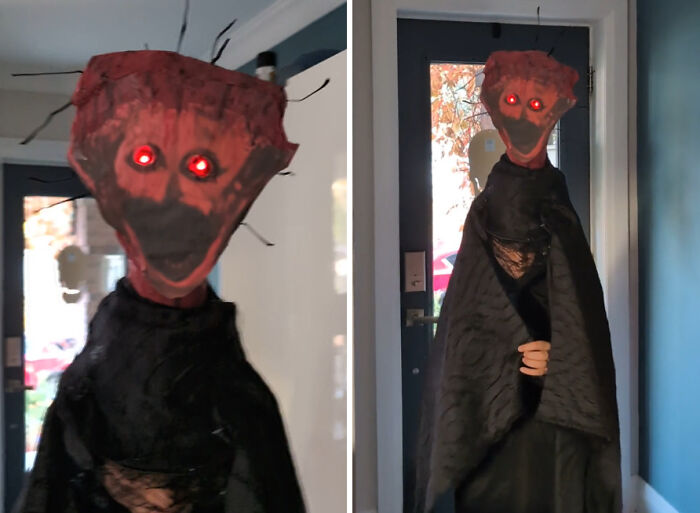 A spooky child Halloween costume featuring a creepy red-faced figure with glowing red eyes and black robes.