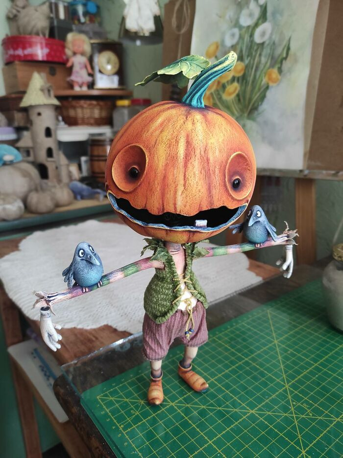Handcrafted pumpkin scarecrow figurine with blue birds for Halloween home decor.